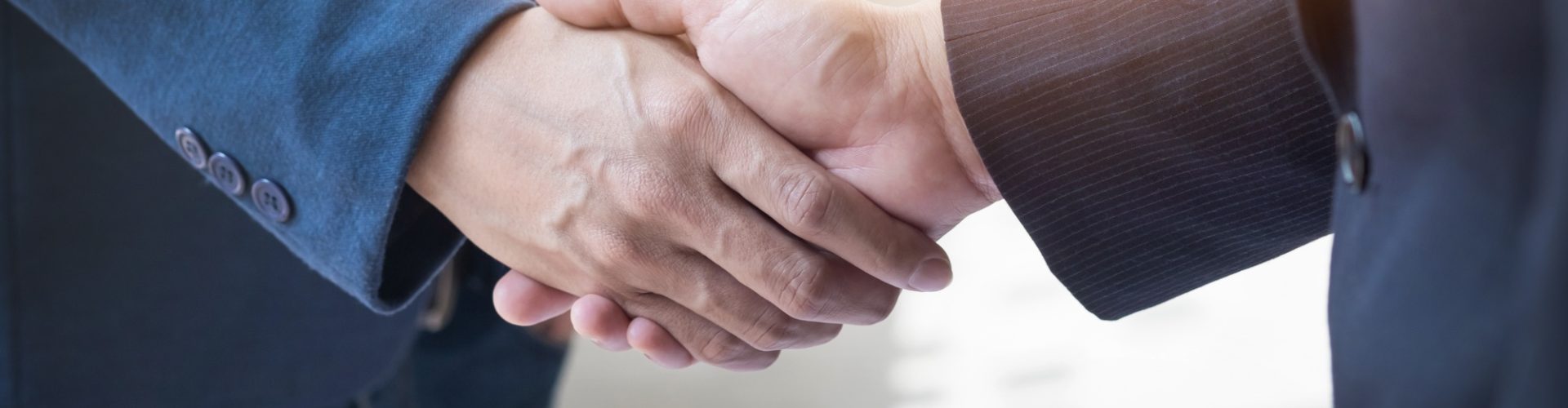 dois-homens-de-negocios-confiantes-apertando-as-maos-durante-uma-reuniao-no-escritorio-sucesso-trato-saudacao-e-conceito-de-parceiro