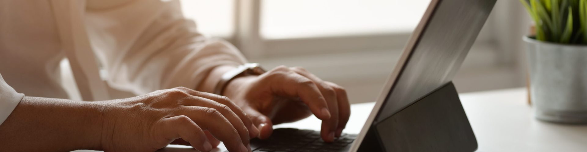 Side view of young professional businessman working on his plan while typing on laptop